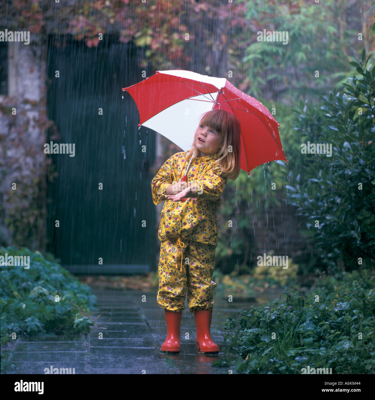 Ragazza con ombrello in caso di pioggia Foto Stock