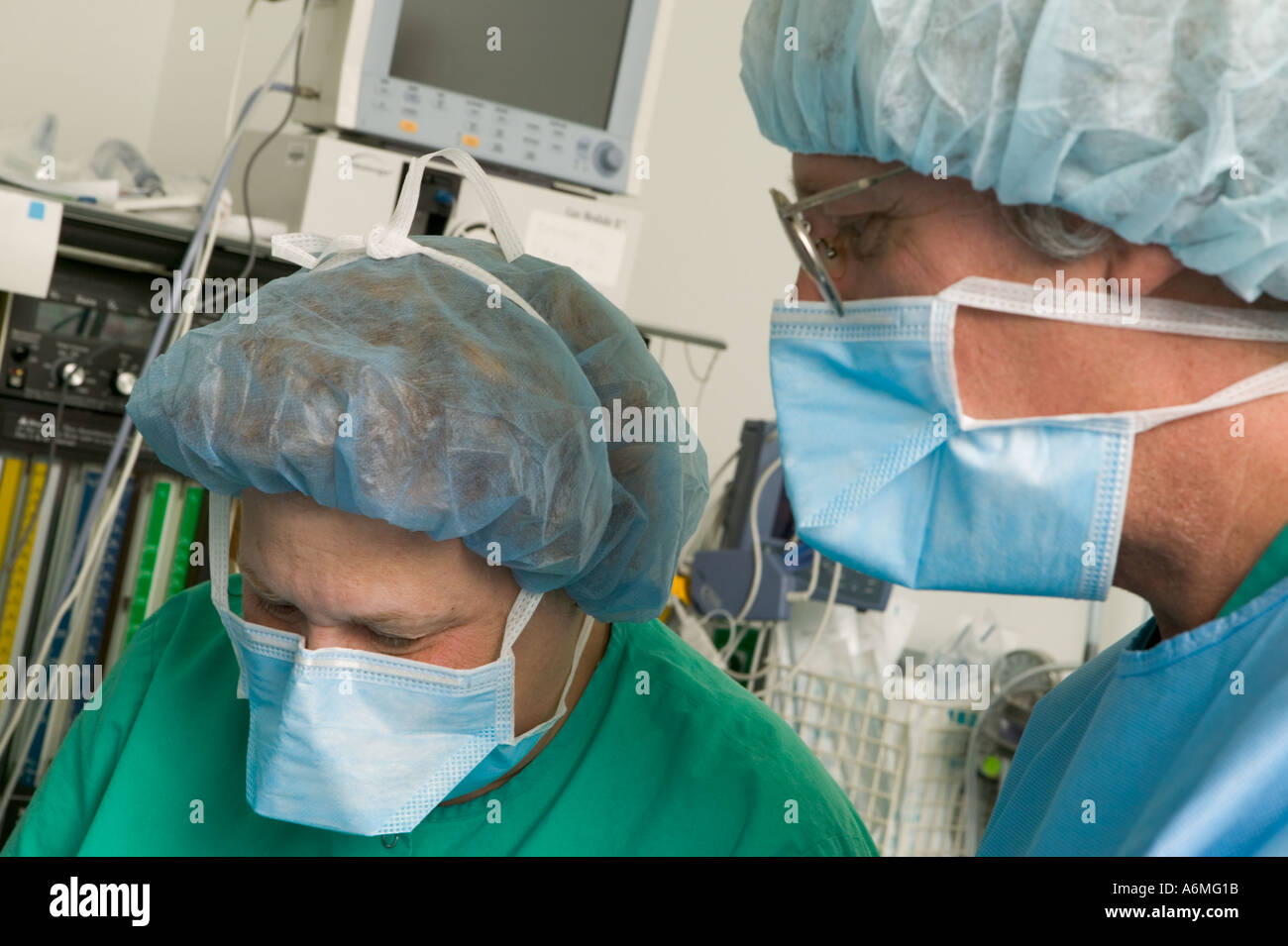 I medici e gli infermieri si riuniscono intorno al tavolo operatorio durante gli interventi chirurgici Foto Stock