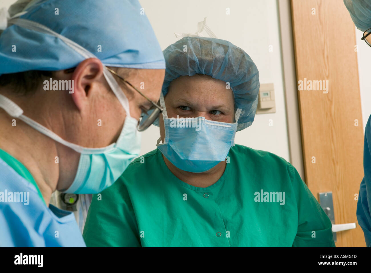 I medici e gli infermieri si riuniscono intorno al tavolo operatorio durante gli interventi chirurgici Foto Stock