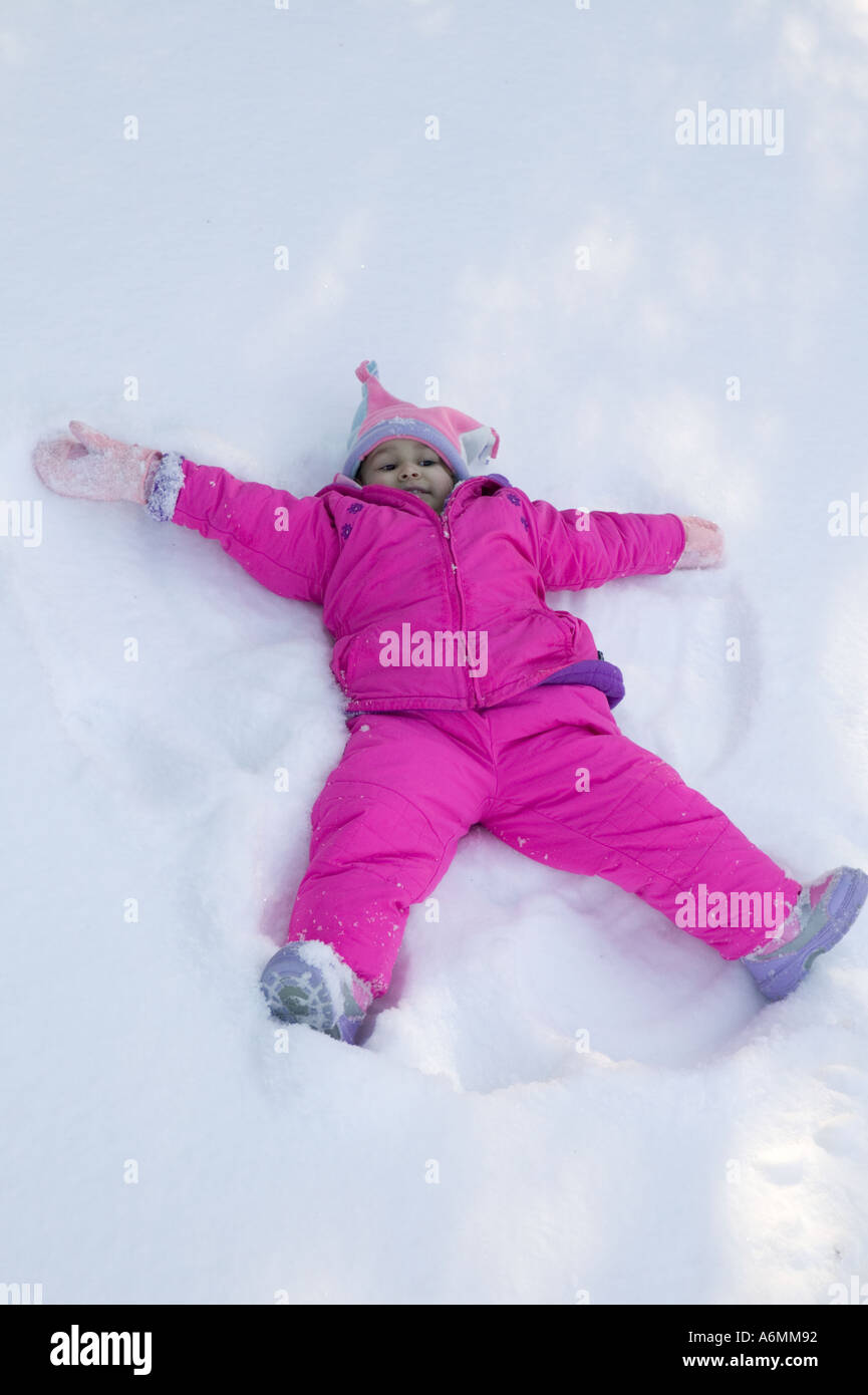 Ragazza di Latina giocando rendendo gli angeli di neve snow Upstate New York Foto Stock