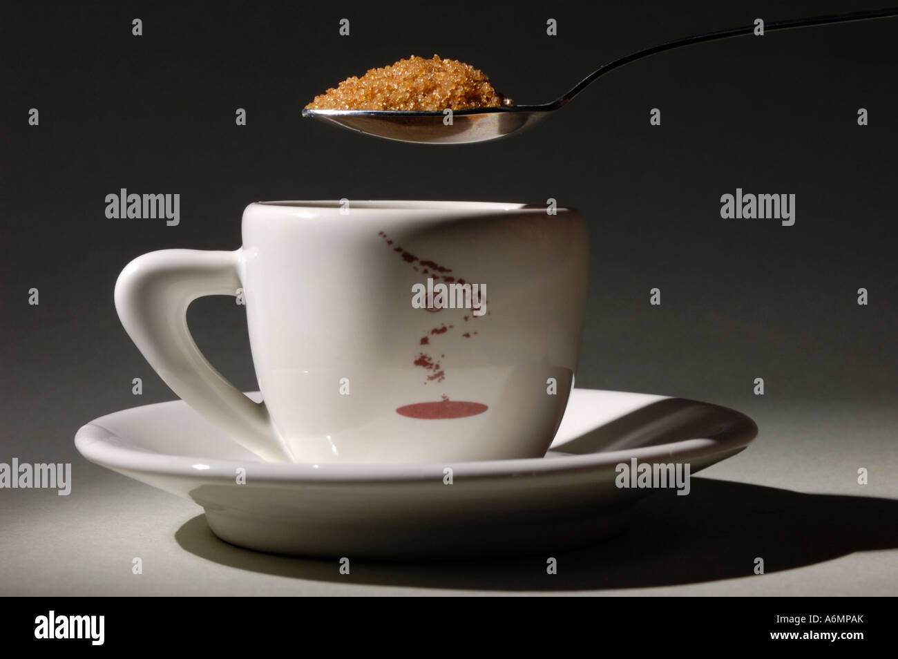 Cucchiaino pieno di zucchero di canna sorseggiando una tazza di caffè Foto Stock