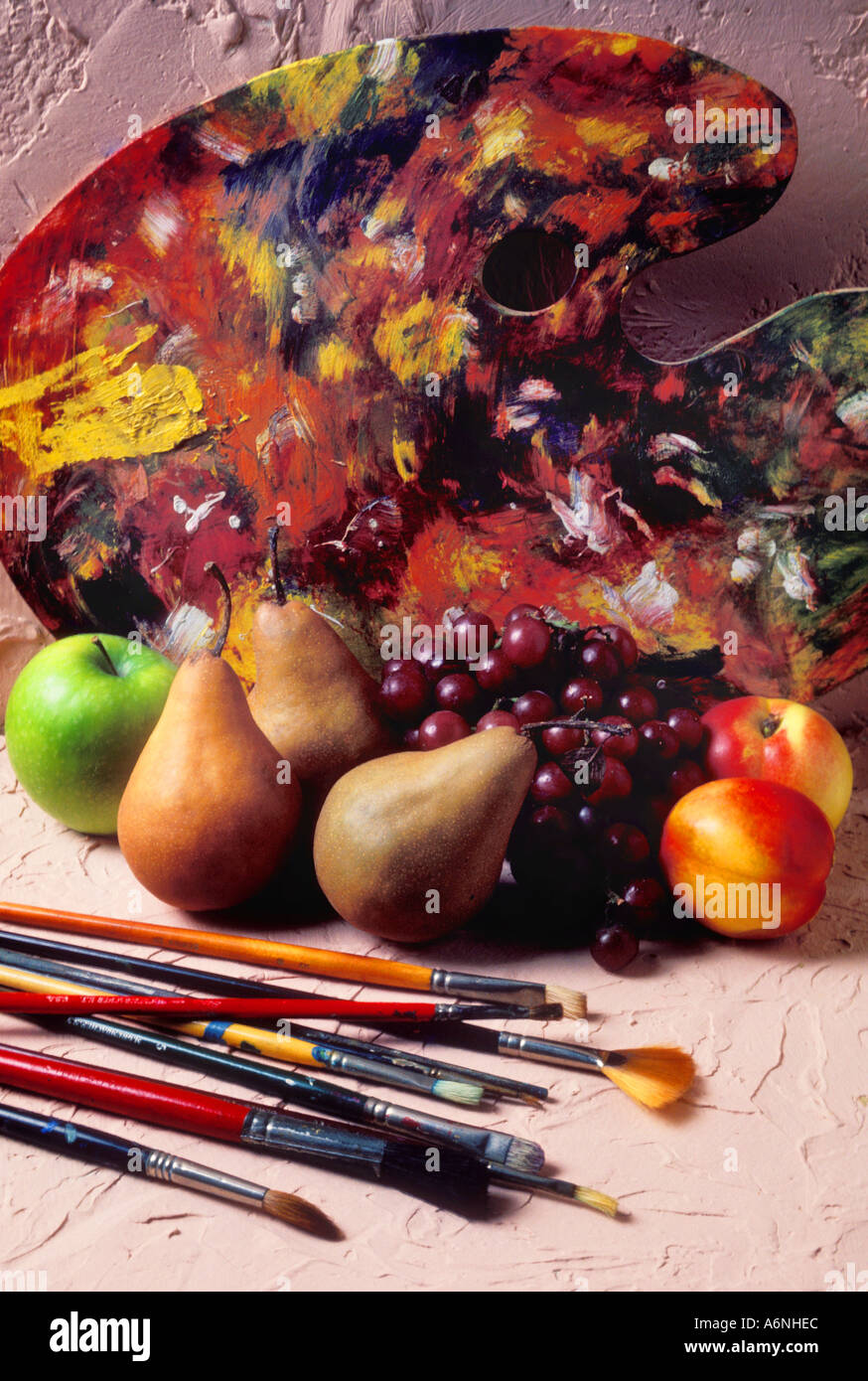 Tavolozza dei pittori con spazzole e frutta Foto Stock