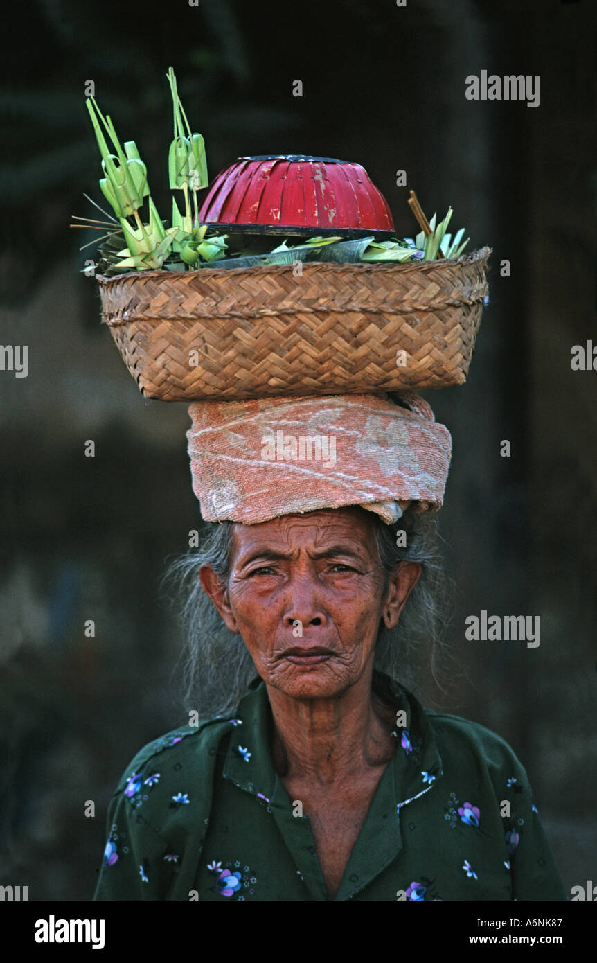 Donna Balinese arriva al tempio laden con offerte di religiosi portati sulla testa luna piena celebrazioni Ubud Bali Indonesia Foto Stock