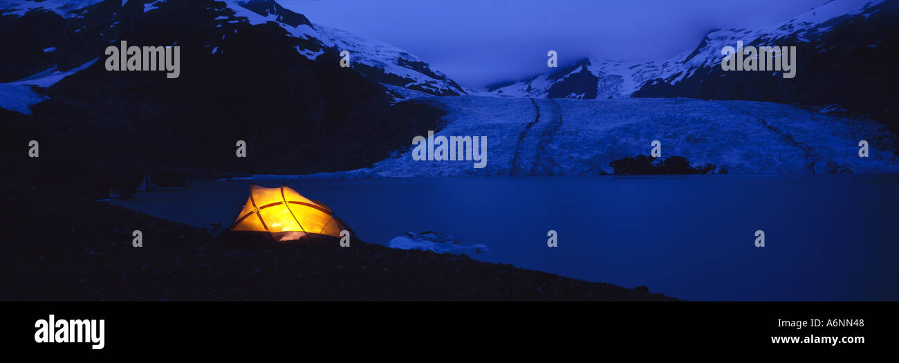 Stati Uniti d'America Alaska Chugach National Forest Backpacker s tenda si illumina di notte sulla morena del ghiacciaio sopra il ghiacciaio Portage Foto Stock