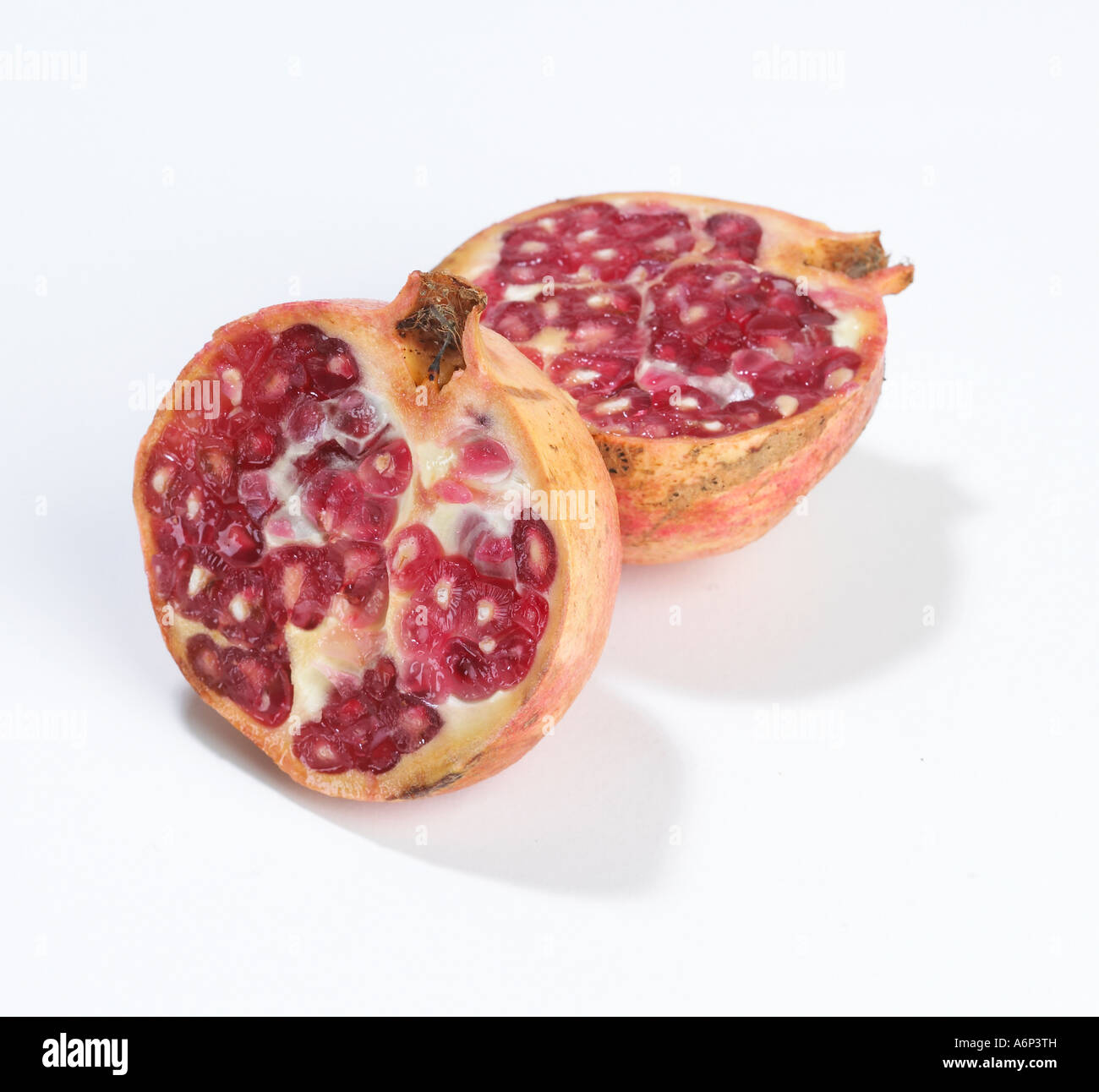 Frutta pommegranate tagliato in due pezzi su sfondo bianco Foto Stock