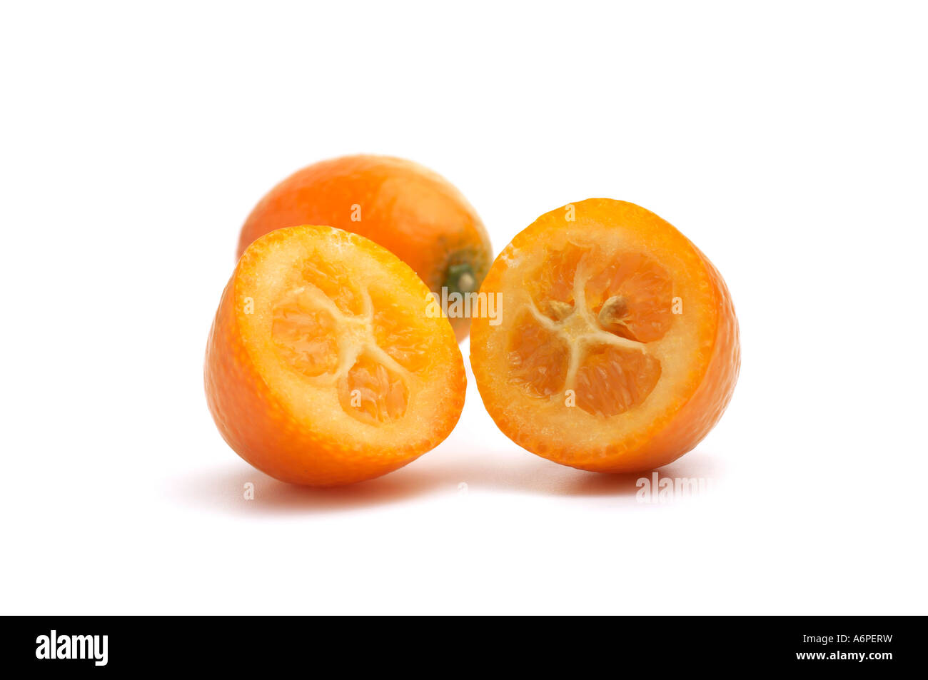 Close up Kumquat con uno tagliato a metà che mostra la carne e i vinaccioli Foto Stock