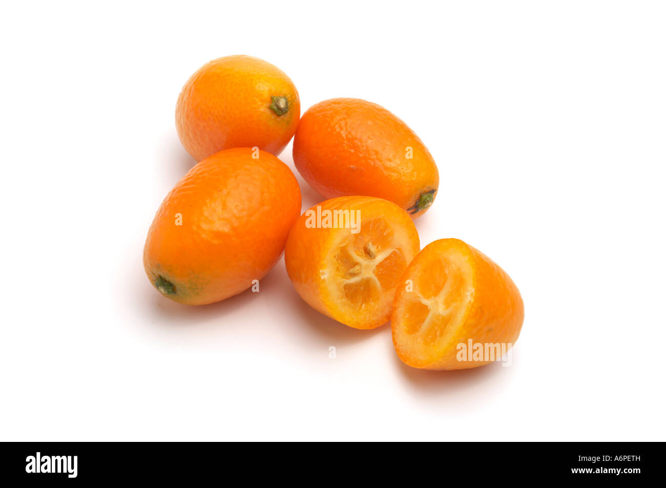 Close up Kumquat con uno tagliato a metà che mostra la carne e i vinaccioli Foto Stock