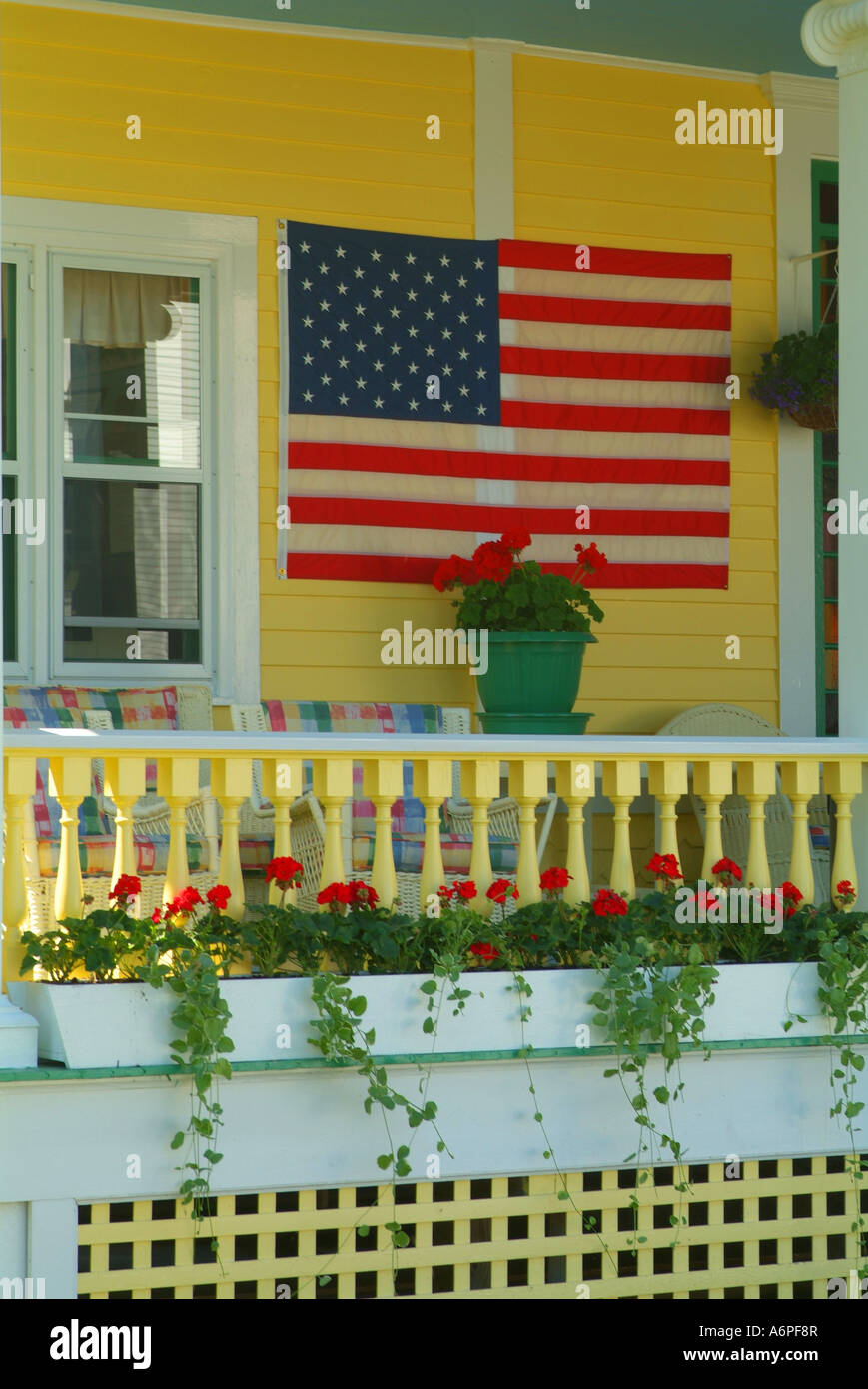 Stati Uniti Michigan isola di Mackinac Lago Huron giallo portico con bandiera americana Foto Stock