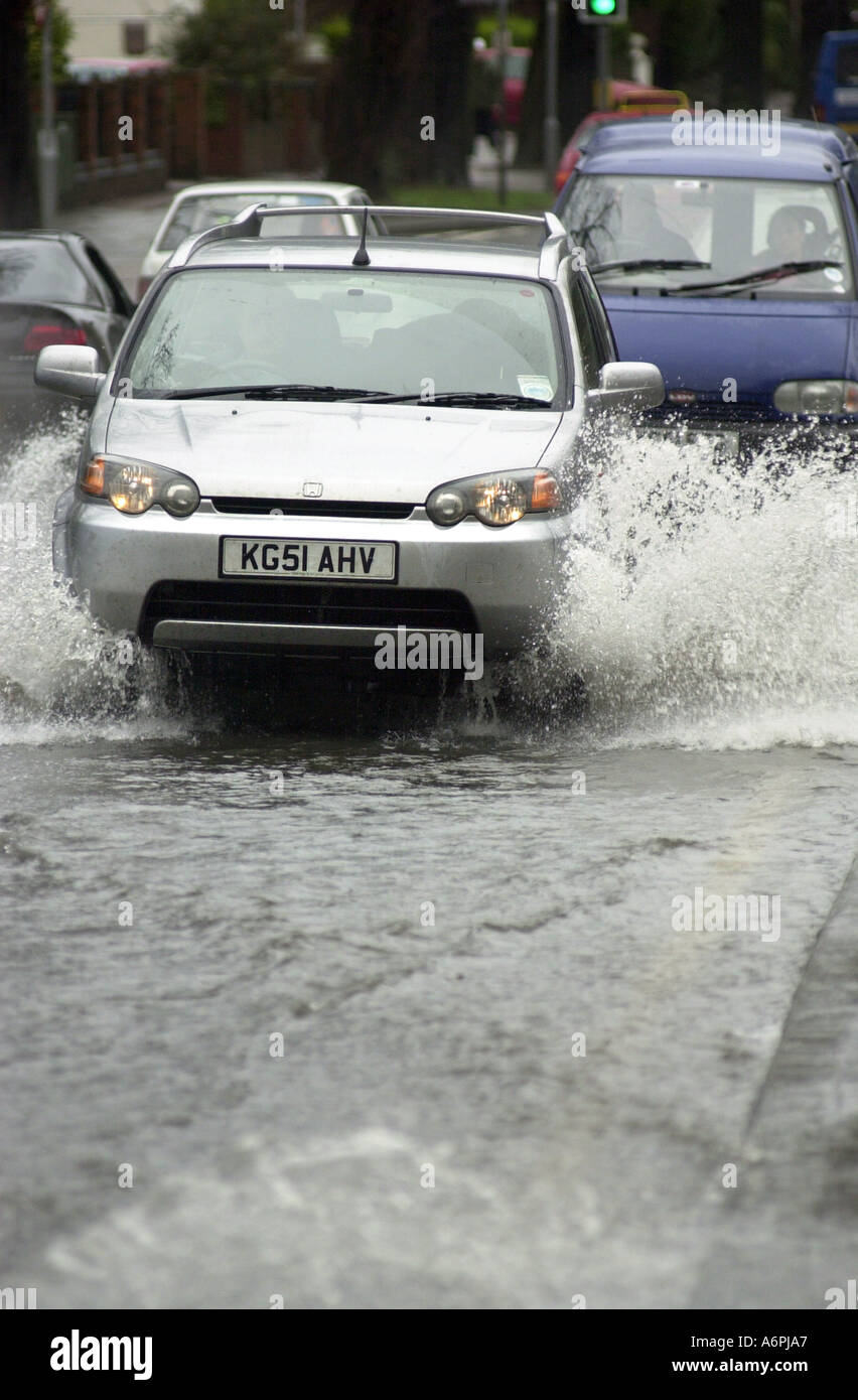 Di automobili che circolano attraverso l'acqua di allagamento nei letti di Luton Regno Unito Foto Stock