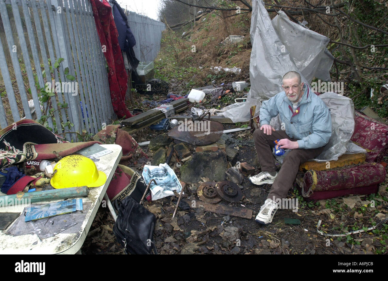 Senzatetto in si abbassa per preparare un pasto nella sua effettuare il cambio camp letti Luton Regno Unito Foto Stock