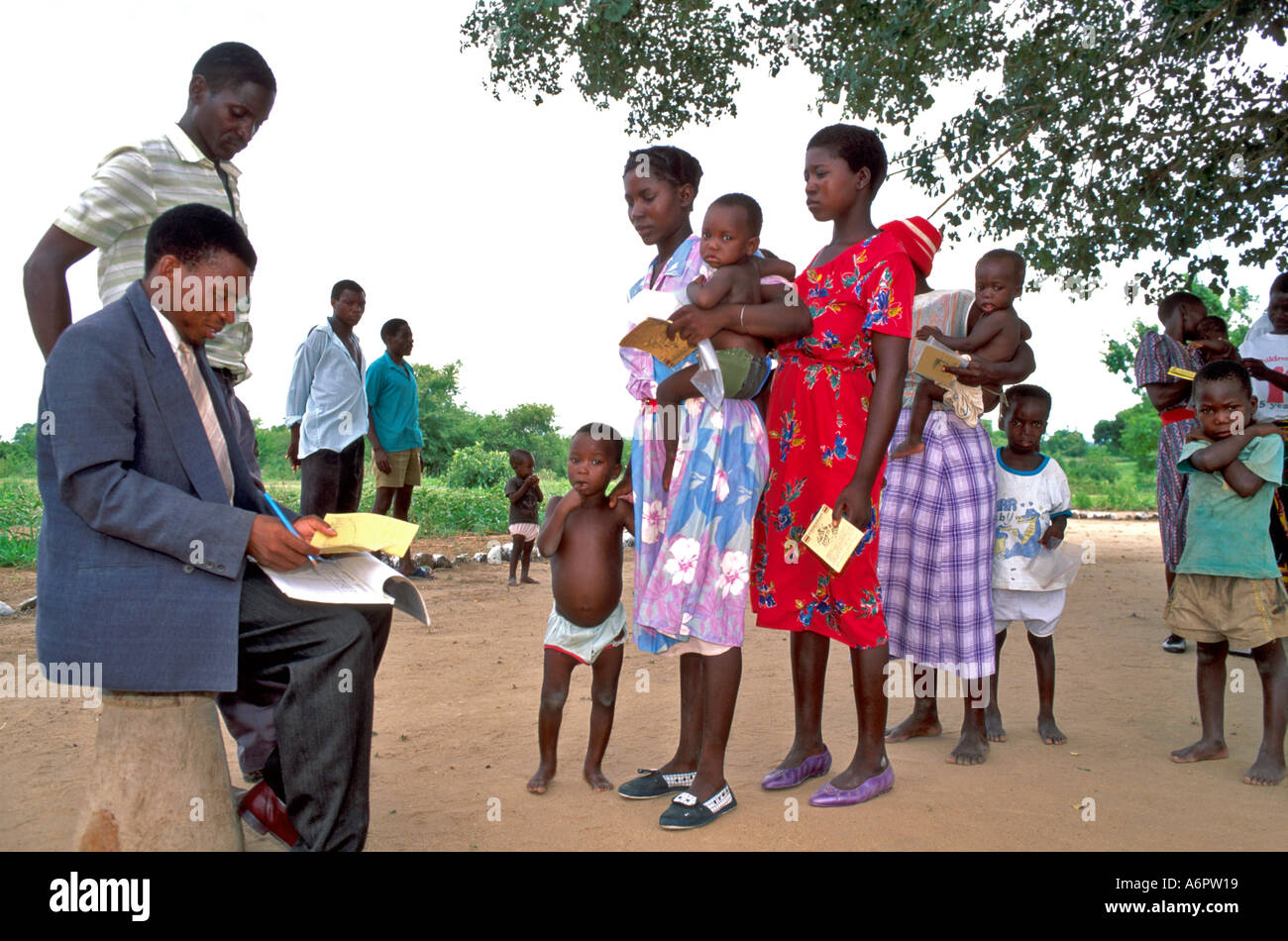 Operatore sanitario che registra i bambini in una clinica di salute rurale all'aperto. Zimabababwe Foto Stock