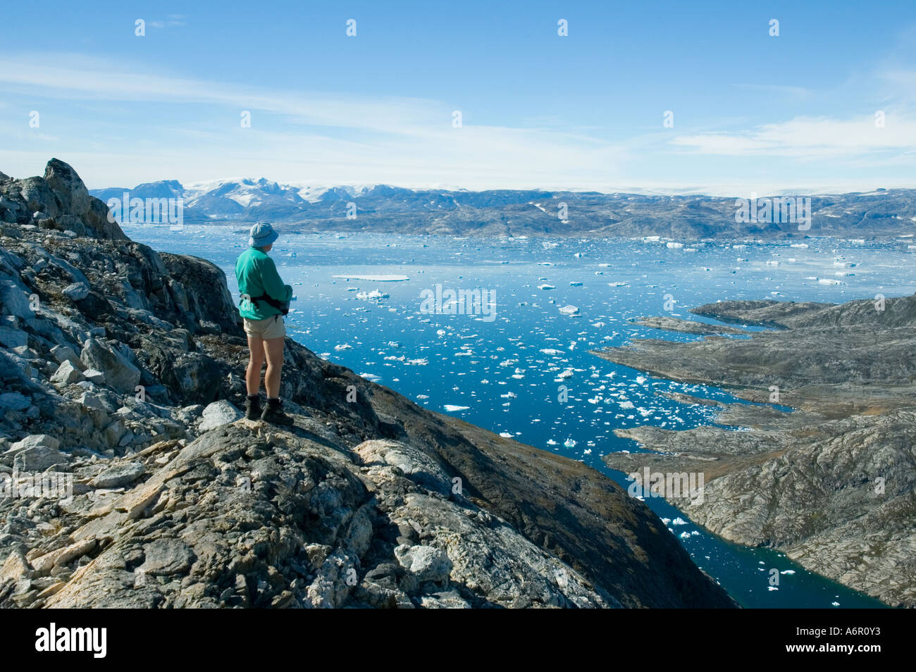 Escursionista guardando attraverso Sermilik Fjord dal Tiniteqilâq cresta est della Groenlandia Foto Stock