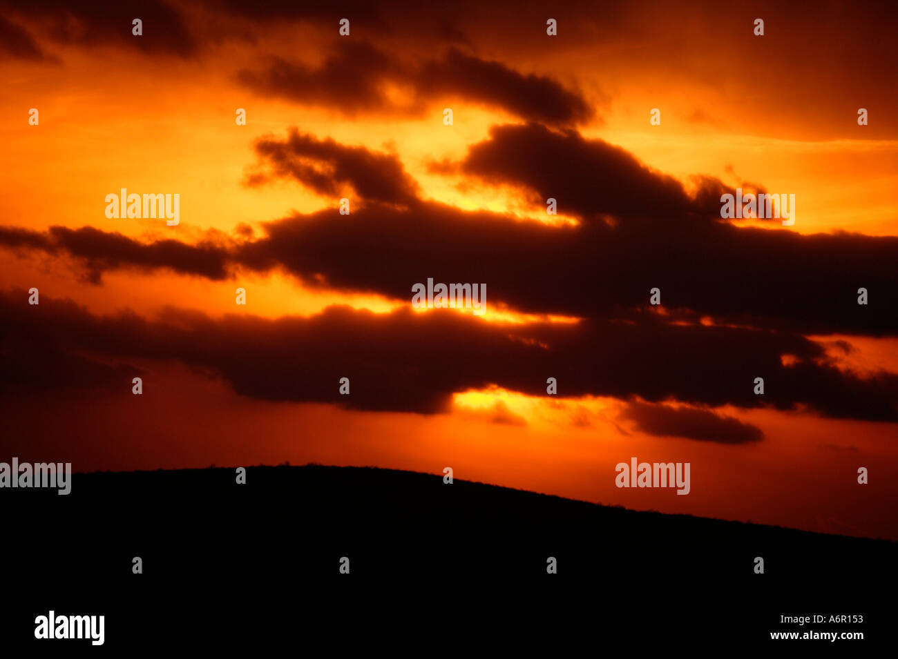 Un bel tramonto Cielo e nubi su una collina distante Foto Stock