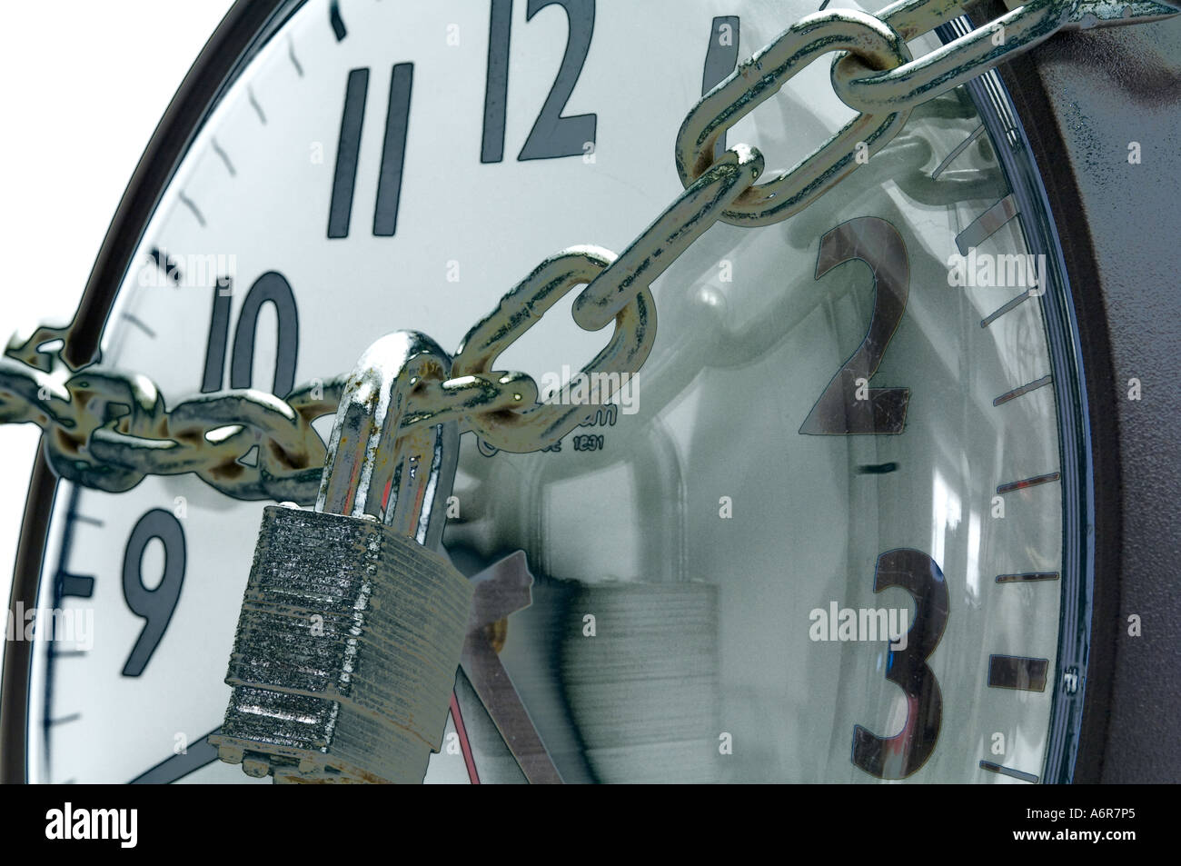 Concetto Visualizza Ingrandimento di orologio da parete in ufficio avvolto con catena e lucchetto Foto Stock