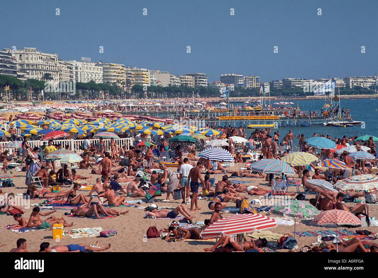 Spiaggia di sovraffollamento al fianco di Boulevard de la Croisette in estate. Cannes, Francia. Foto Stock