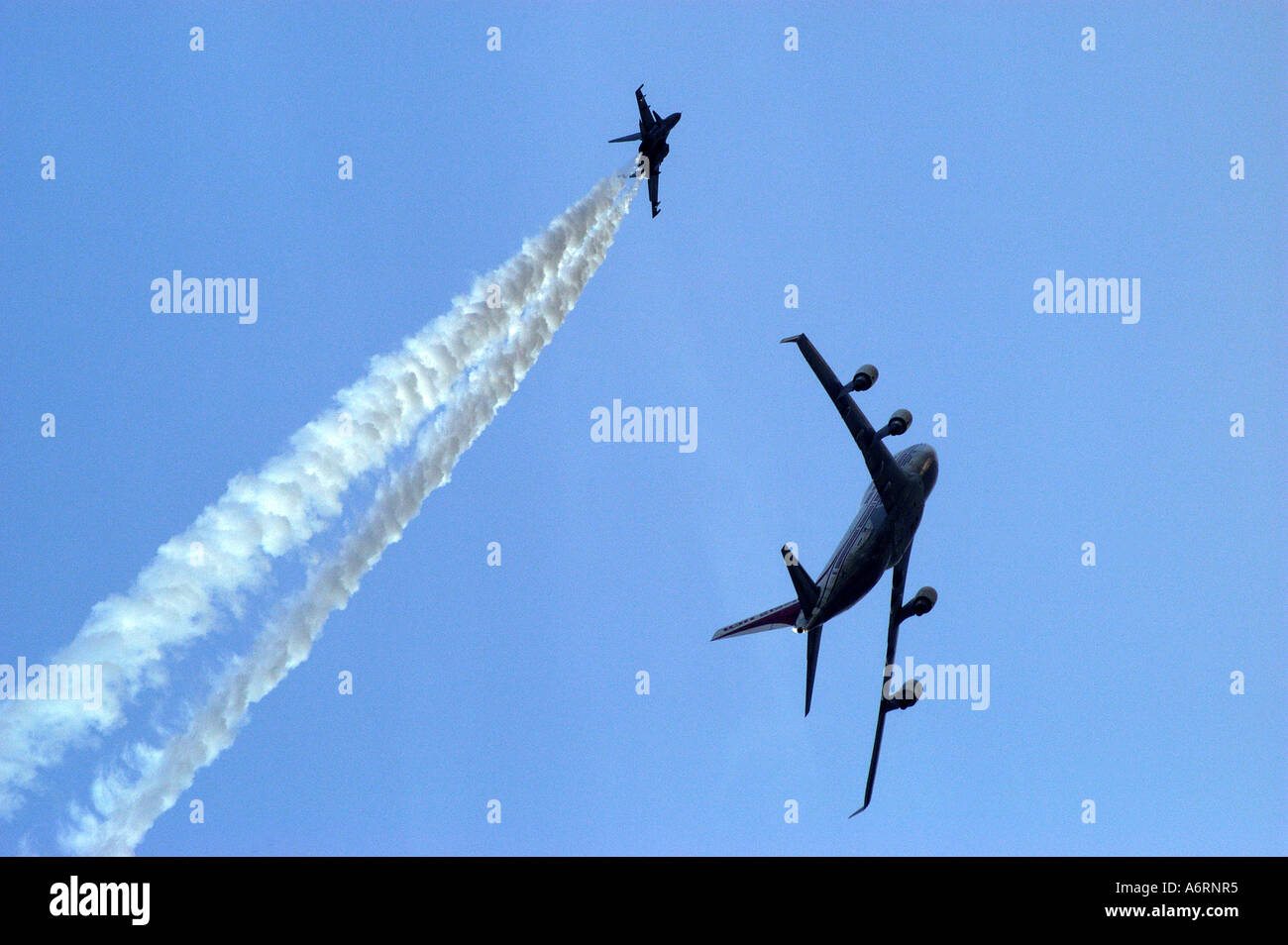 ASB77303 aereo commerciale volare passato con aerei da combattimento durante air show Foto Stock
