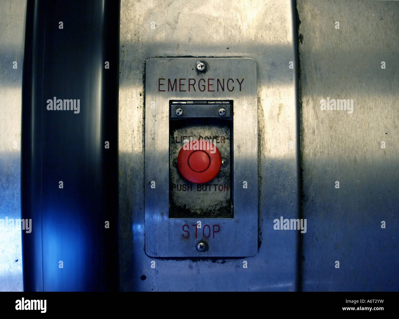 Filthy, rosso di 'arresto di emergenza' pulsante su un vecchio, usura-indossato escalator in Manhattan. Foto Stock