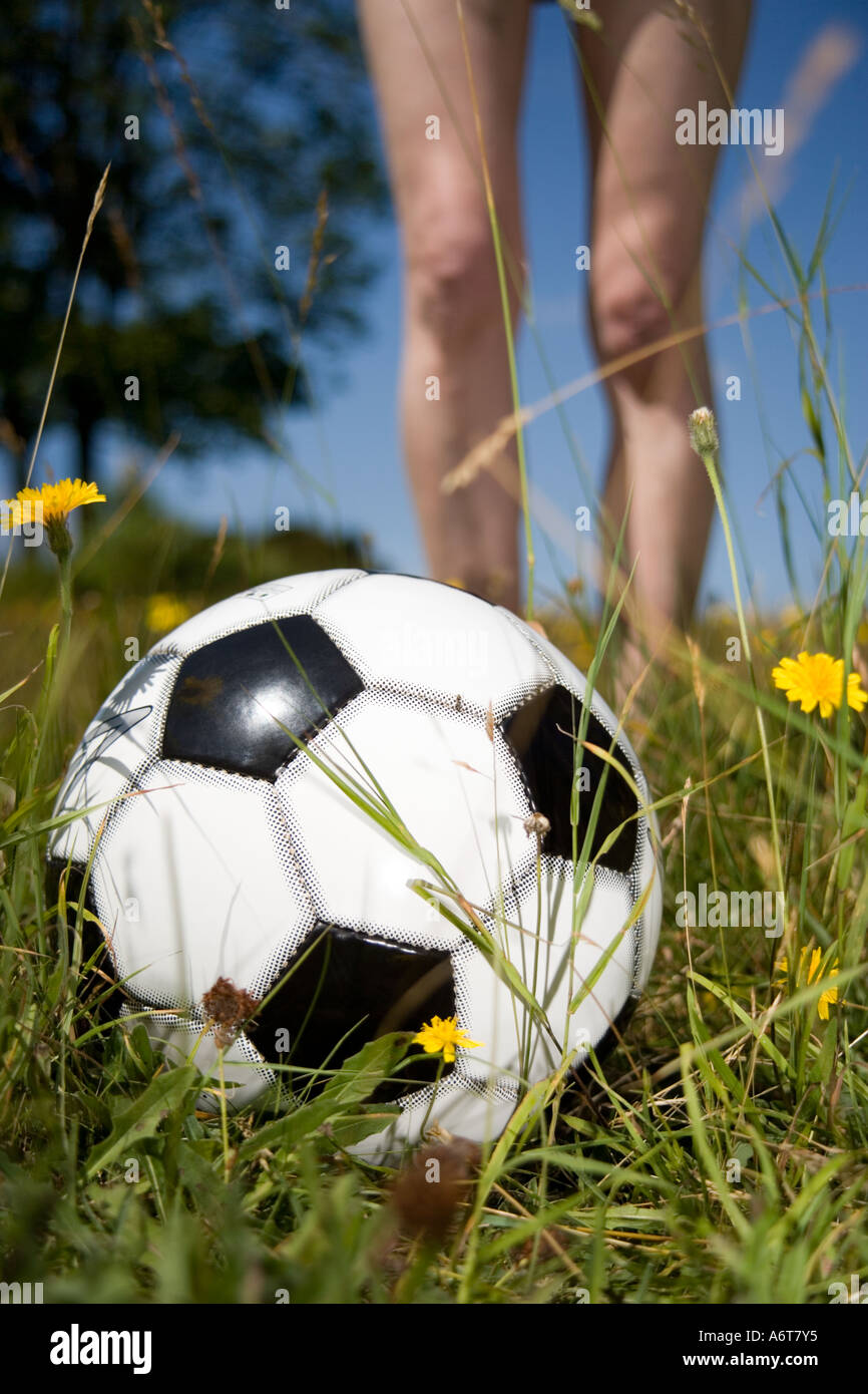 Pallone da calcio sul prato davanti la donna per le gambe Foto Stock