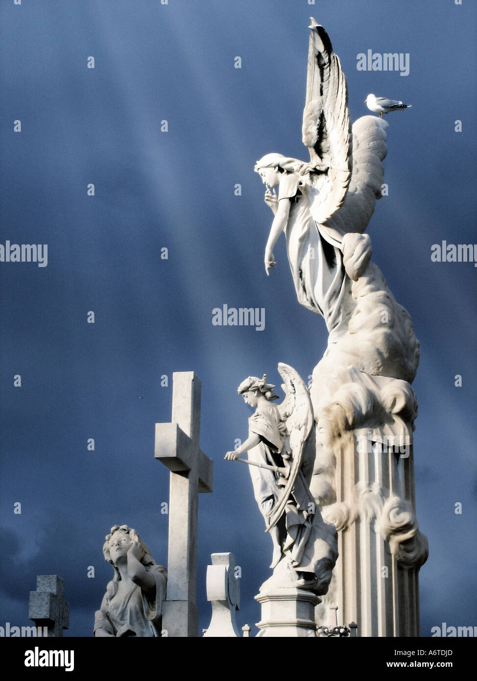 Angeli alati e croce in un cimitero Foto Stock