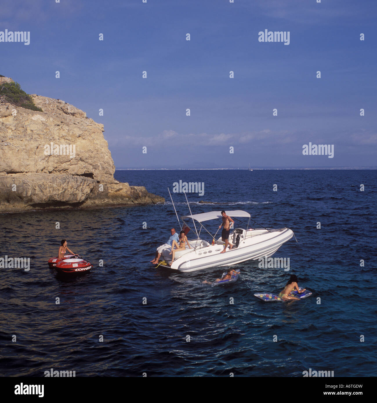 Divertimento al sole e frolics in mare con nervatura di carta portali - barca rigida gonfiabile al di ancoraggio in una tranquilla insenatura di cala ( ) Foto Stock