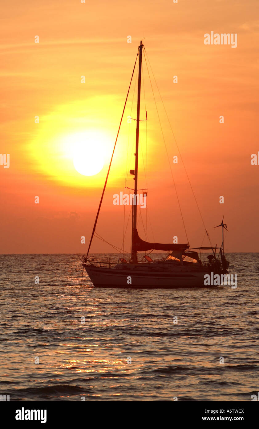 Imbarcazione a vela in parte anteriore del sunrise presso la costa dell'isola di Koh Kradan - Mare delle Andamane, Thailandia, Asia Foto Stock