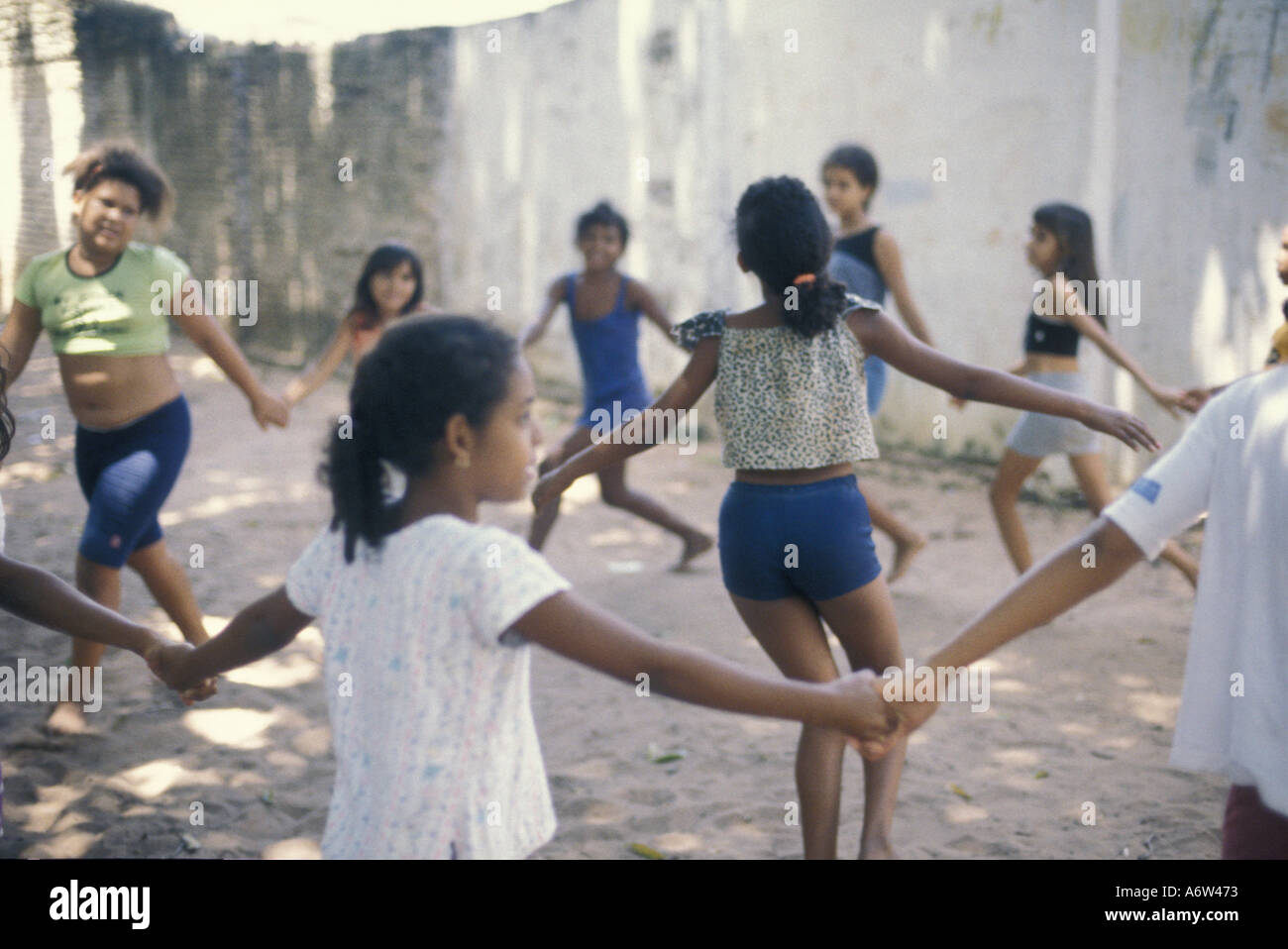 Multi-etnico gruppo di bambini poveri gioca ring-intorno a-a-rosea, Natal, Rio Grande do Norte stato, nel nordest del Brasile. Foto Stock