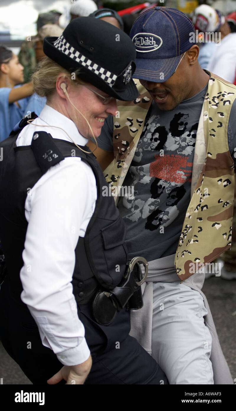 Poliziotta ballando con uomo a nottinghill carnival nottinhill Foto Stock