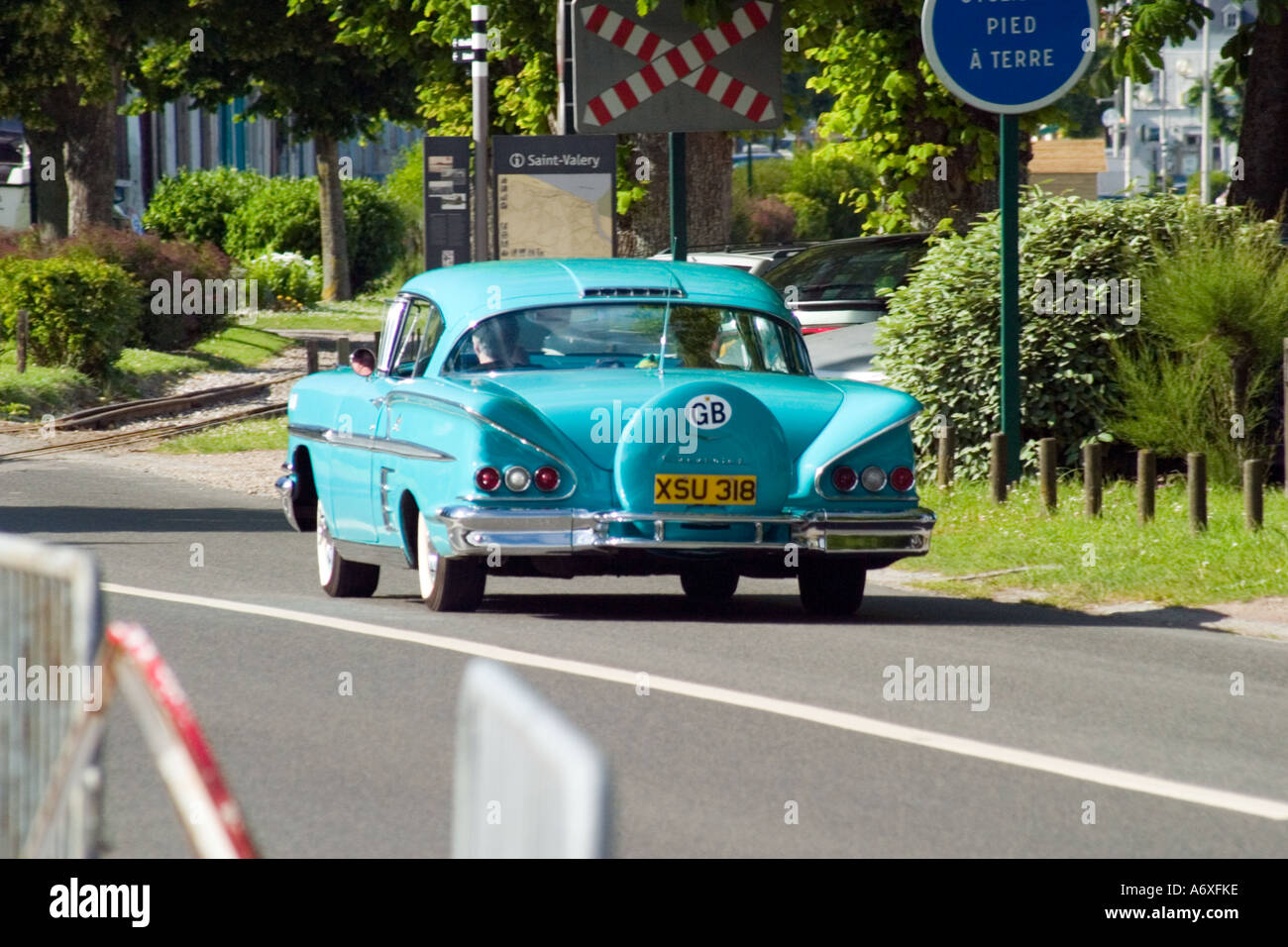 Blu brillante vettura americana su piastre inglese passando oltre il passaggio a livello St Valery sur Somme Francia Foto Stock