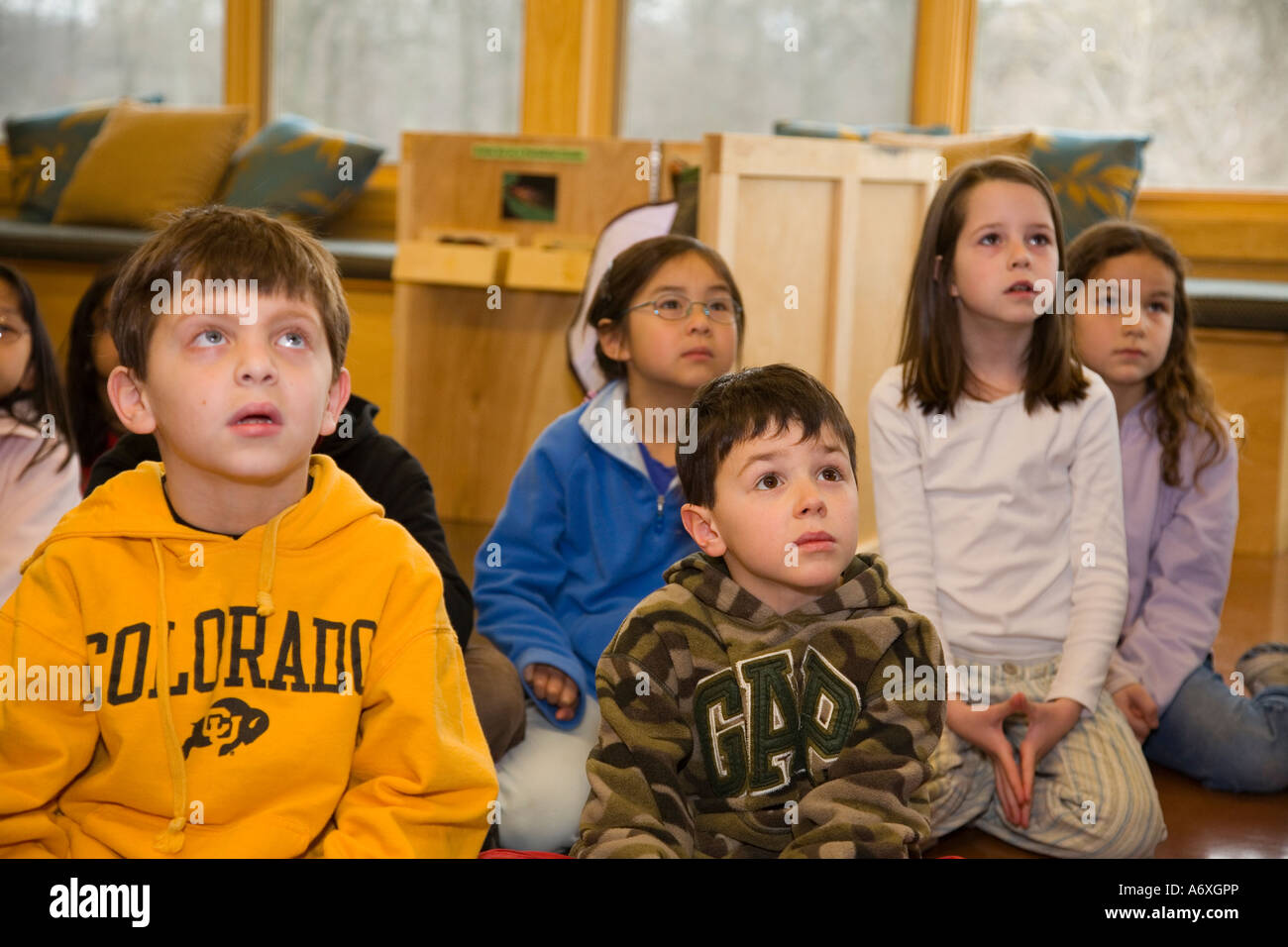 Conserva Ryerson gli studenti della scuola elementare sit piano le espressioni facciali come guarda il filmato intensamente Foto Stock
