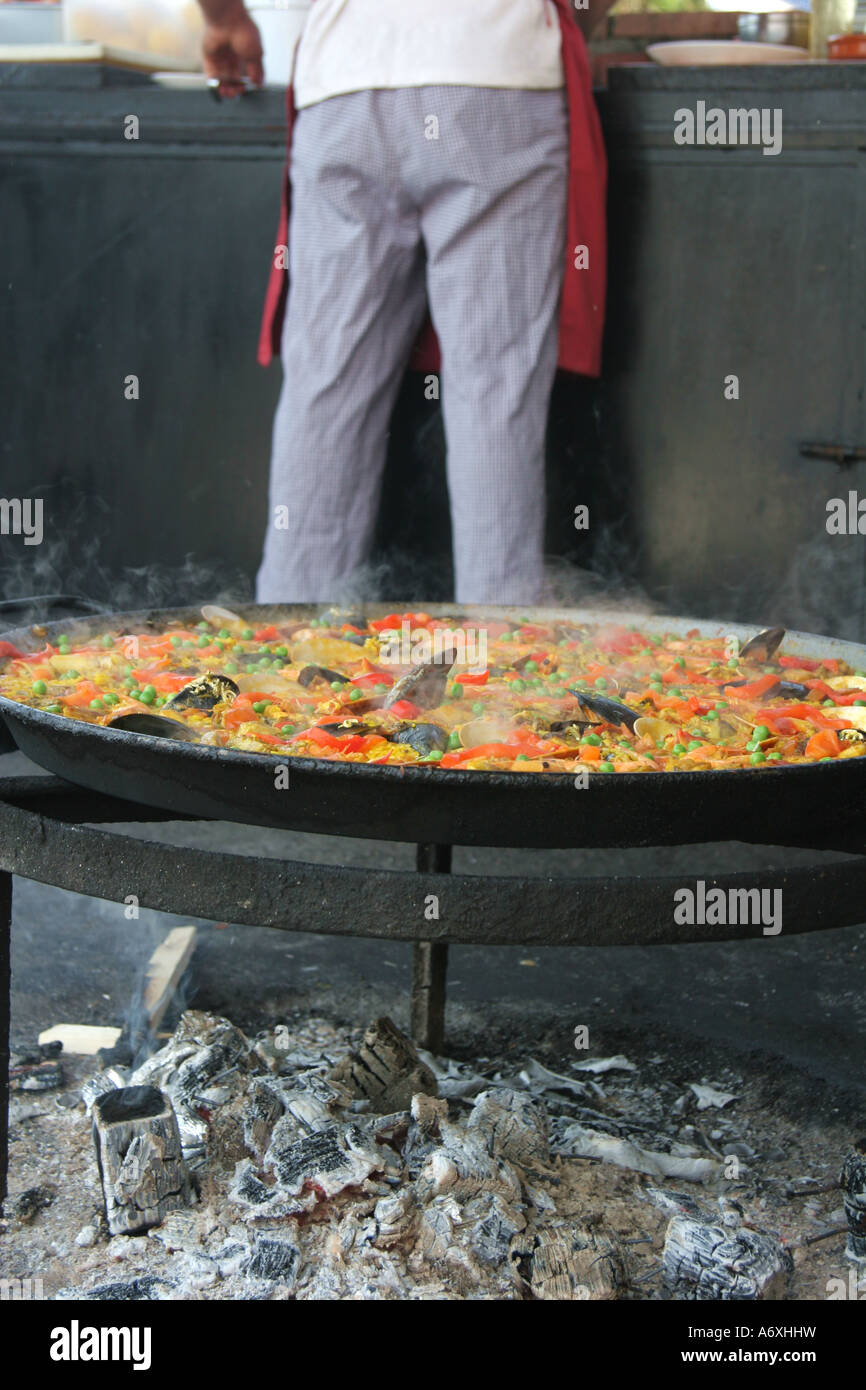 La paella di essere cucinati in spagnolo barbecue sulla spiaggia Foto Stock