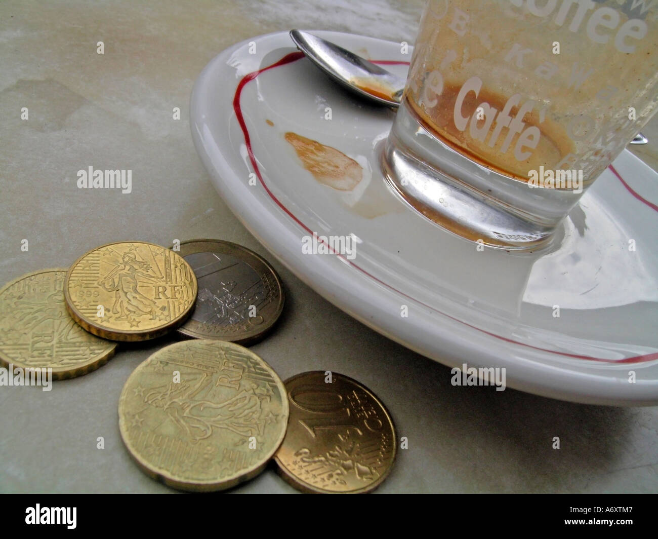 Tazza vuota glas di espresso expresso con monete sul tavolo Foto Stock