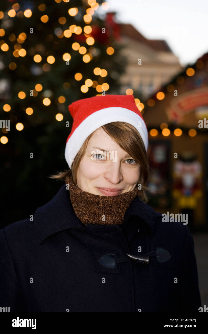 Donna che indossa un cappello da Babbo Natale in un mercato di Natale Berlino Germania Foto Stock