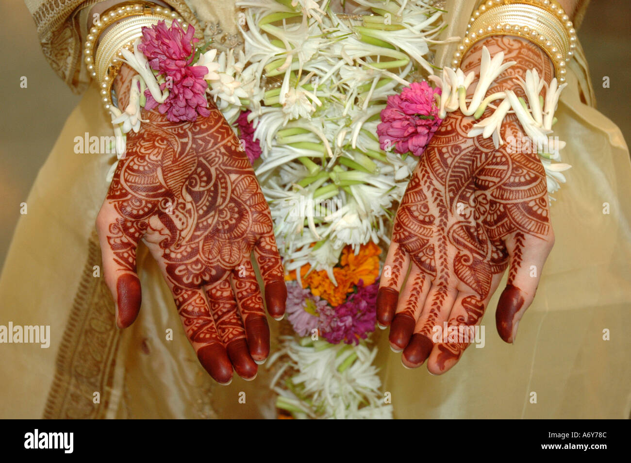 Sposa Indù ad essere henné mani dipinte e fiori freschi di ornamenti Foto Stock