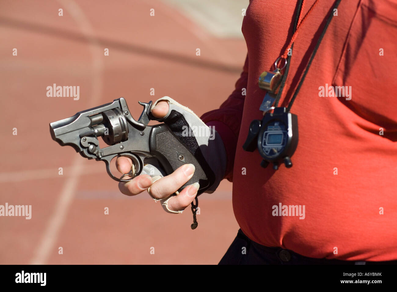 Uomo in possesso di una pistola di partenza su una via di corsa Foto Stock