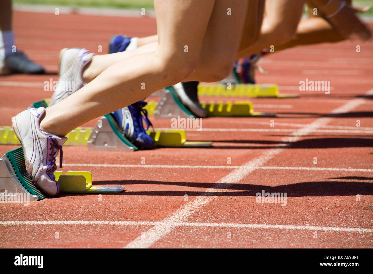 Le atlete con i piedi in blocchi di partenza su una via di corsa Foto Stock