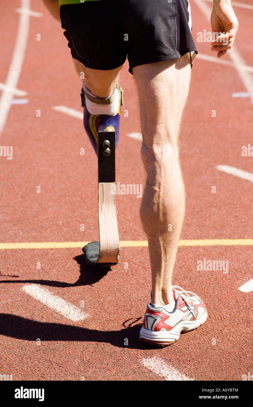 Atleta con una gamba protesico in piedi alla linea di partenza di una gara Foto Stock
