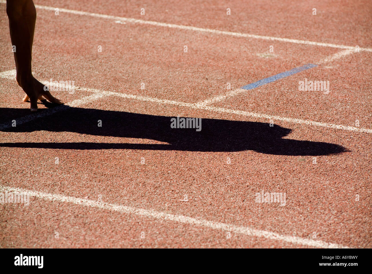 Ombra di un runner in posizione di partenza su una traccia Foto Stock