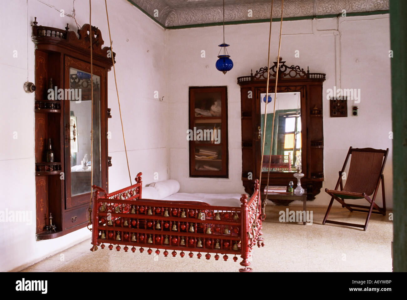 Area con posti a sedere con tradizionale hitchkar sospeso sedile oscillante nel tradizionale restaurata casa Pol Ahmedabad Gujarat India Foto Stock