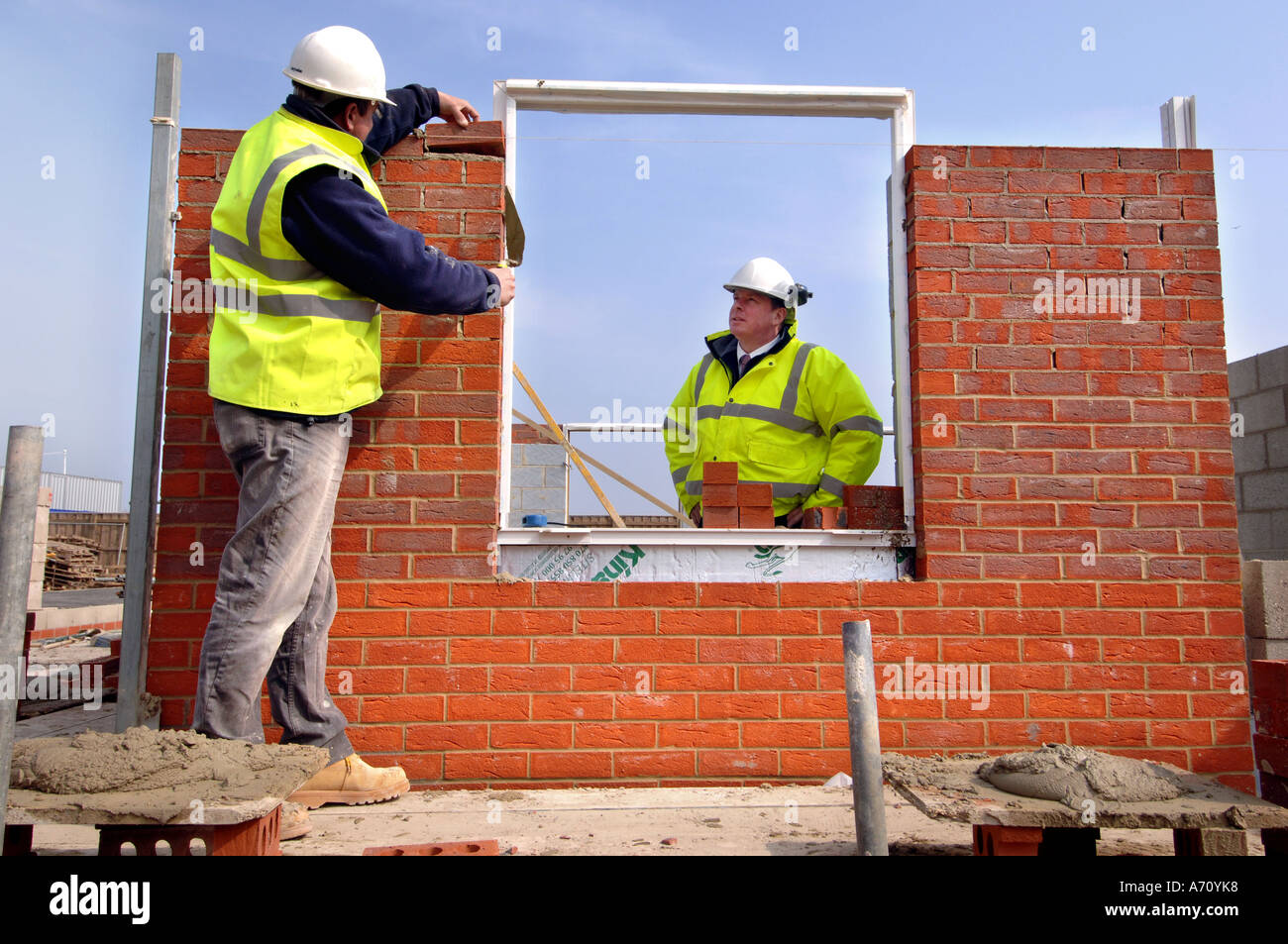 Muratori al lavoro su un alloggiamento dello sviluppo Foto Stock