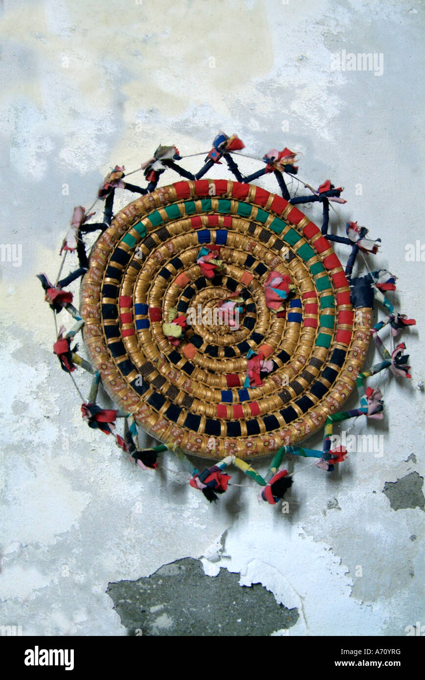 Multi colore colore basket weave tessuto piastra piana tabella mat appendere appeso tipico cerchio etnico spirale circolare parete dipinta di bianco t Foto Stock