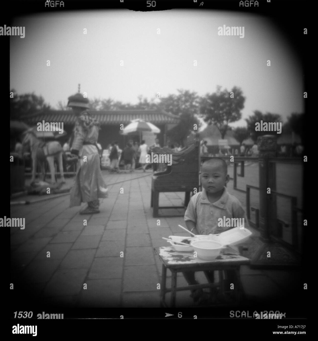 Asia Cina Pechino sfocate immagini in bianco e nero del giovane ragazzo di mangiare il pranzo a photo studio istituito nella Città proibita Foto Stock