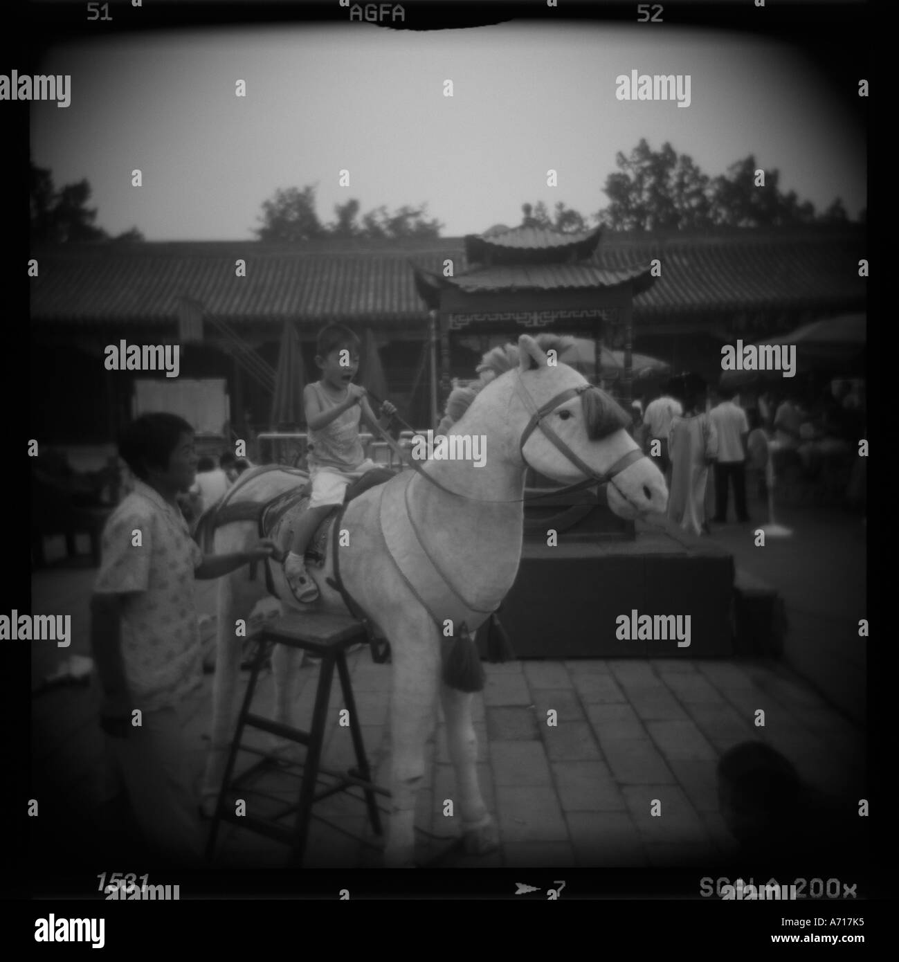 Asia Cina Pechino sfocate immagini in bianco e nero del giovane ragazzo che posano su falsi pony a photo studio nella Città proibita Foto Stock