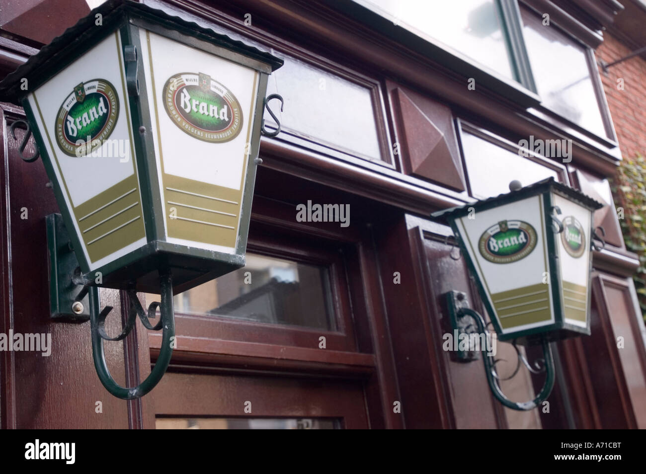 Lanterne che pubblicizzano birra belga di marca su una facciata in legno scuro del pub a Leeuwarden, Frisia, Olanda. Foto Stock