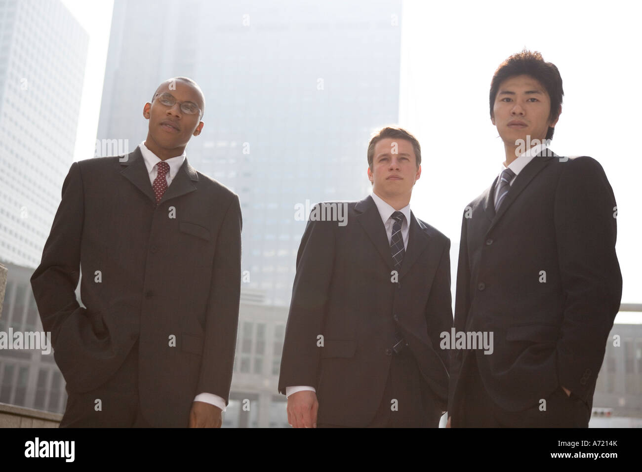Tre uomini di affari in piedi che guarda in telecamera Foto Stock