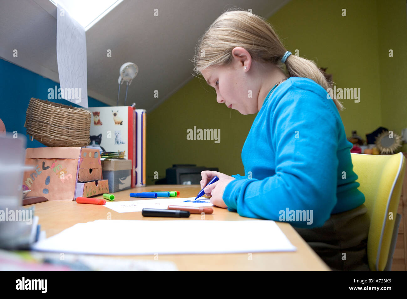 Una ragazza adolescente facendo un disegno nella sua camera da letto Foto Stock