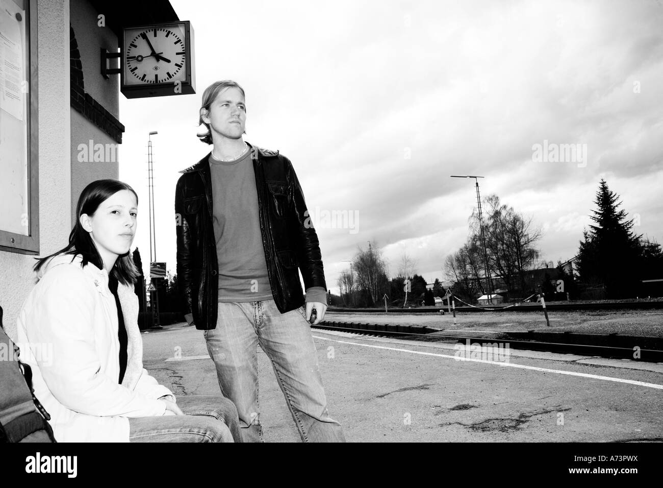 Coppia giovane presso una stazione ferroviaria Foto Stock