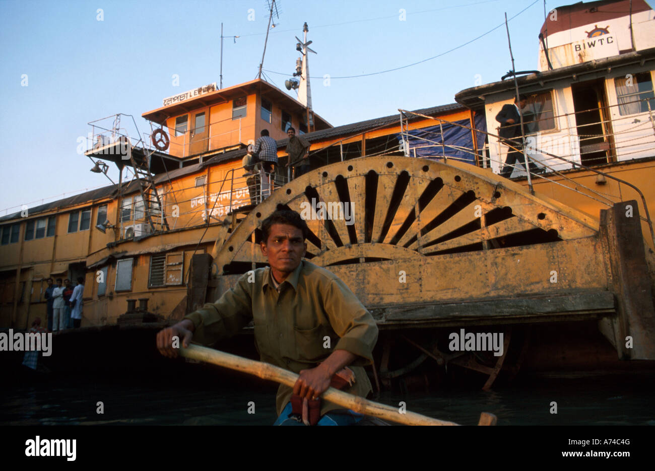 Uomo di canottaggio a razzo con battello a vapore in background Sadarghat vecchia Dhaka Foto Stock
