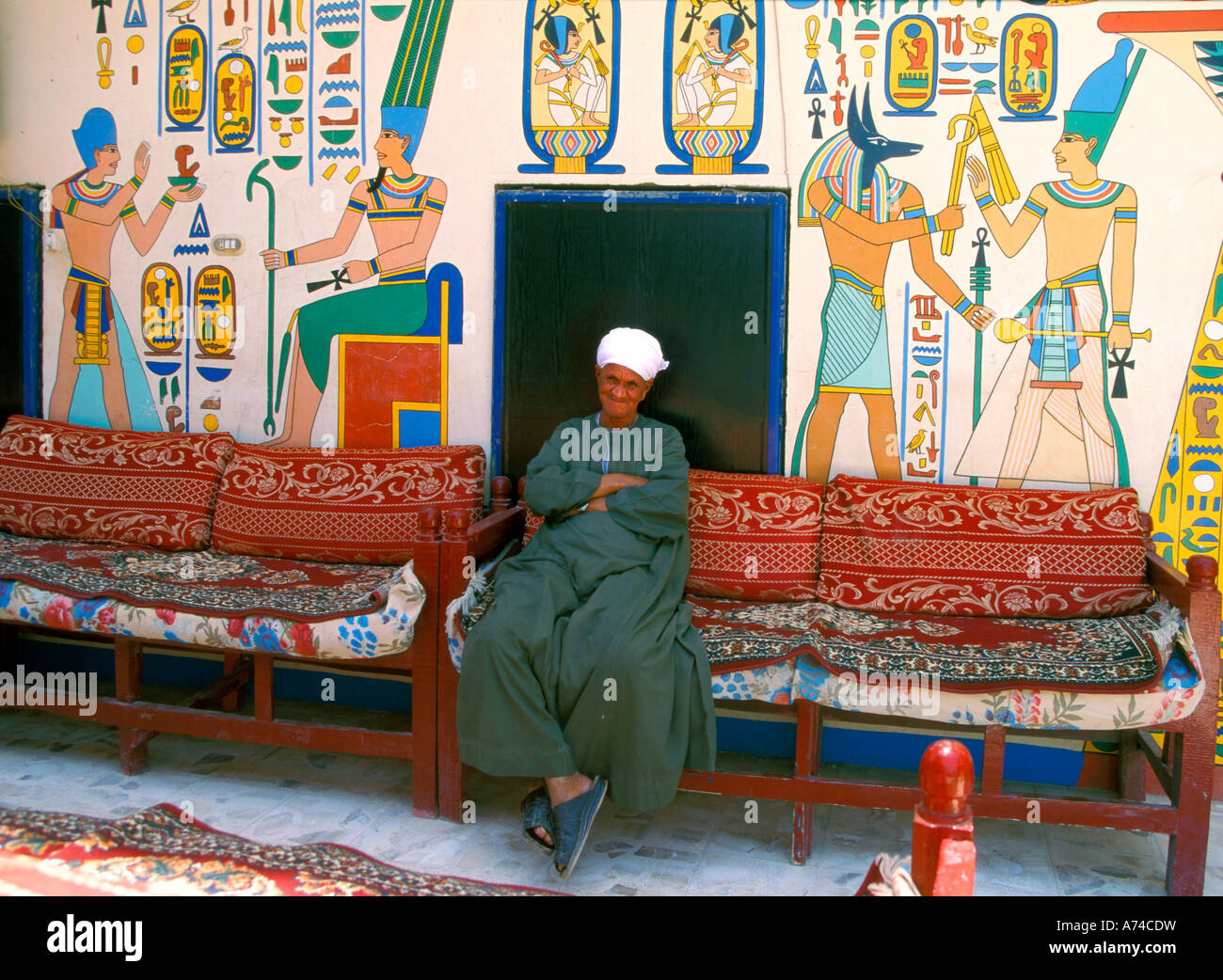 Egyptian uomo seduto da pitture murali Foto Stock