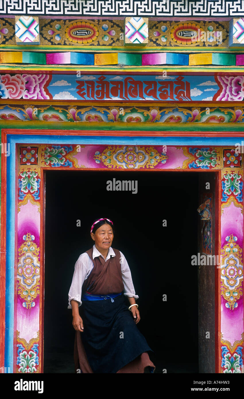 Donna in piedi nel portale decorato porta surround stile tibetano Foto Stock