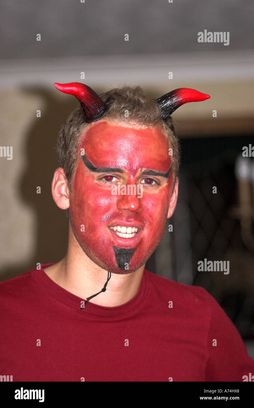 Giovane uomo con la faccia dipinta come diavolo per la festa di Halloween Foto Stock